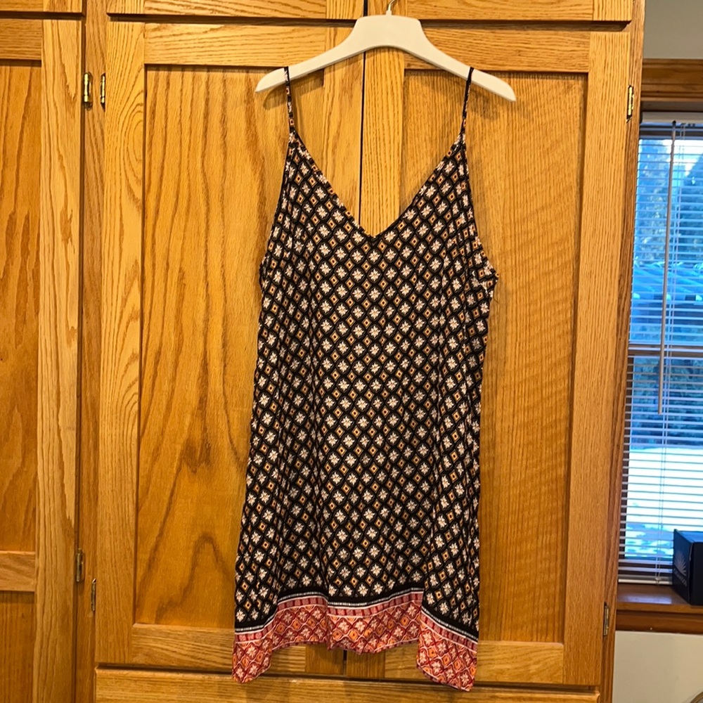 Black dress with white orange and red details.